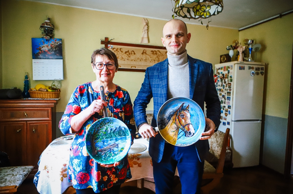 Starosta wraz z malarką trzymający patelnie z malunkami