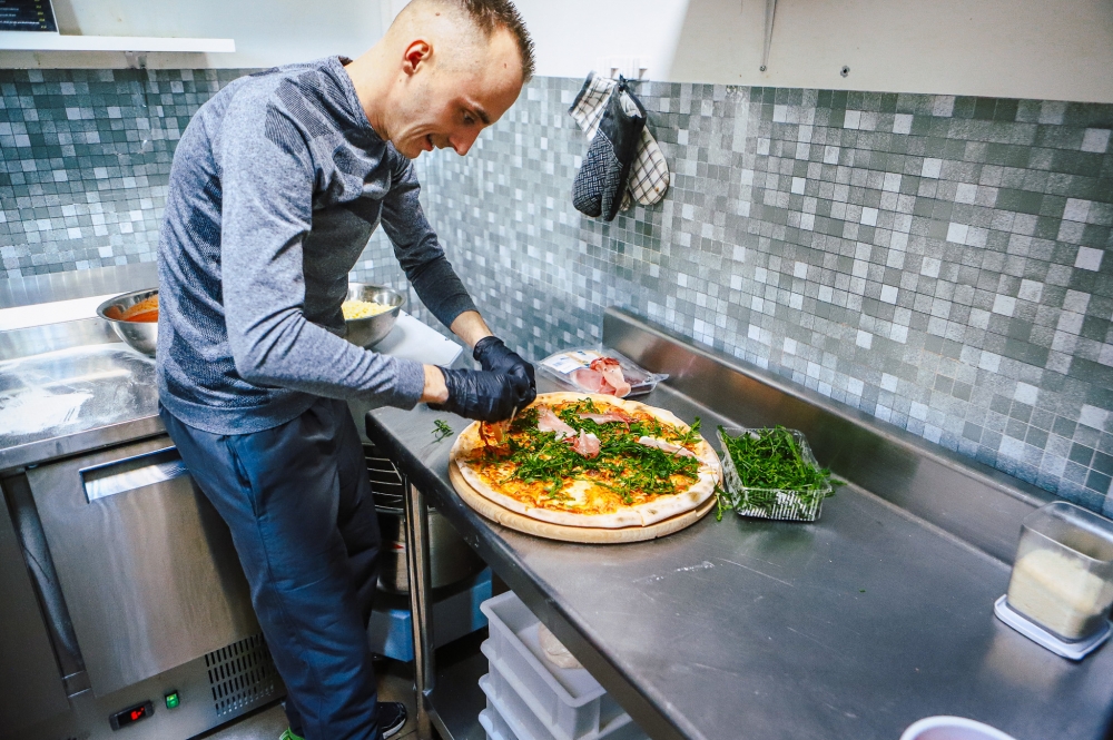 Pizzerman podczas przygotowywania pizzy
