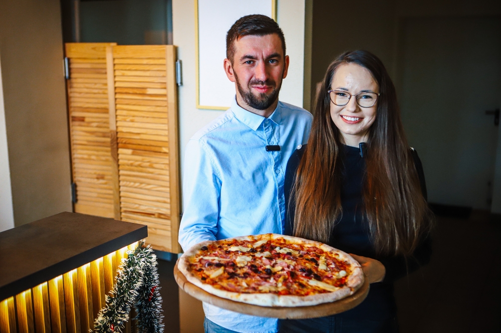 Właściciele pizzerii wraz z pizzą
