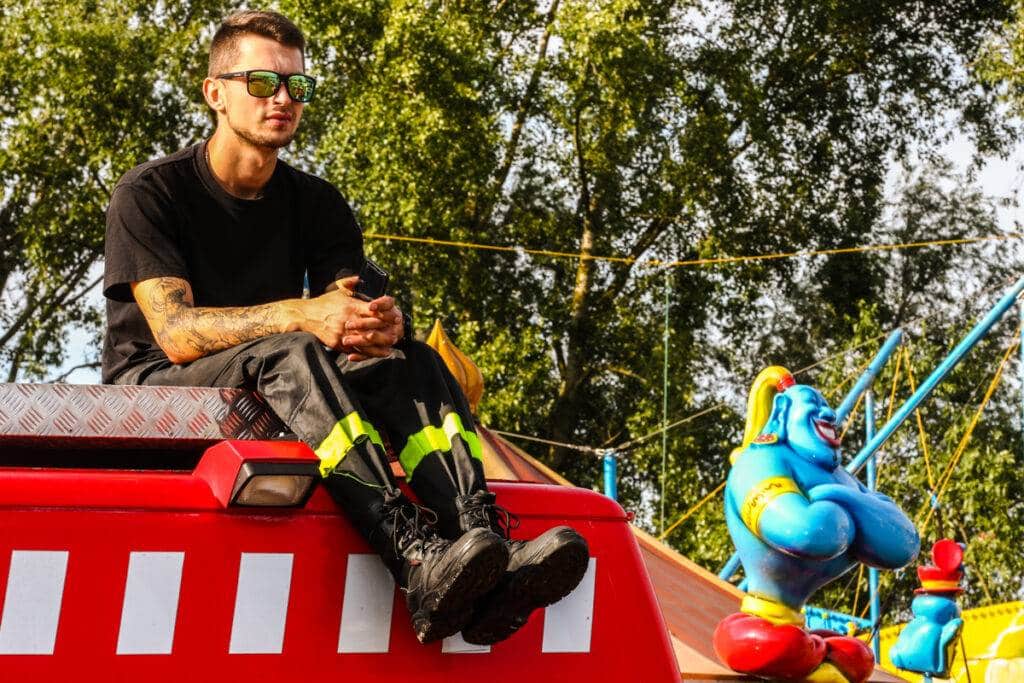 Strażak siedzący na dachu wozu strażackiego