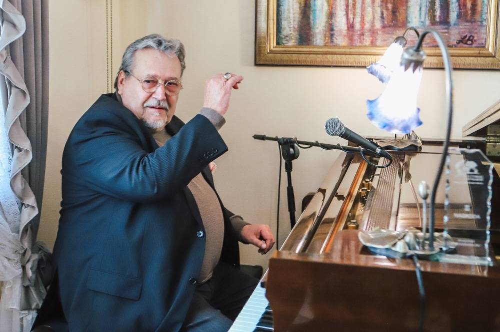 Gospodarz siedzący przy instrumencie klawiszowym