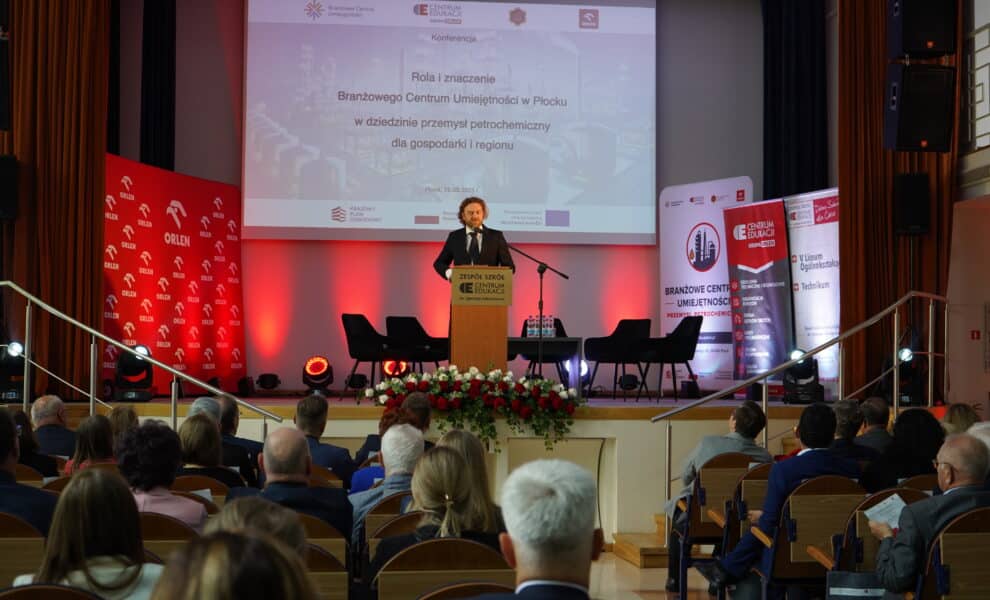 Na zdjęciu odbywa się konferencja dotycząca roli Branżowego Centrum Umiejętności w Płocku, z prezentacją na temat znaczenia tego ośrodka w przemyśle petrochemicznym dla lokalnej gospodarki.