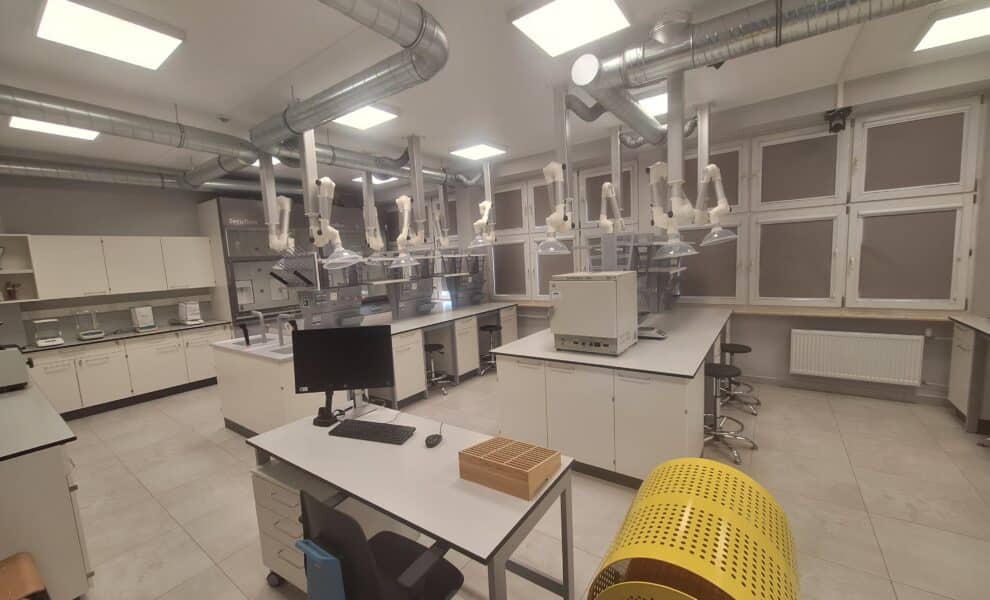 Nowoczesne laboratorium z jasnym oświetleniem, stołami roboczymi i sprzętem do analizy.