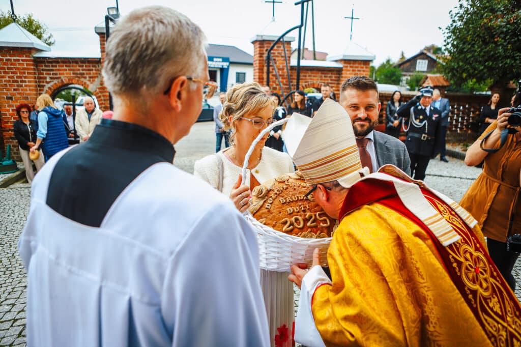 Biskup całuje chleb dożynkowy