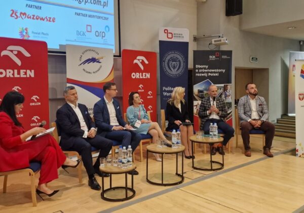 Na zdjęciu przedstawiono panel dyskusyjny podczas III Płockiego Forum Gospodarczego, gdzie siedzą uczestnicy w różnych strojach, a w tle widoczne są logotypy sponsorów.