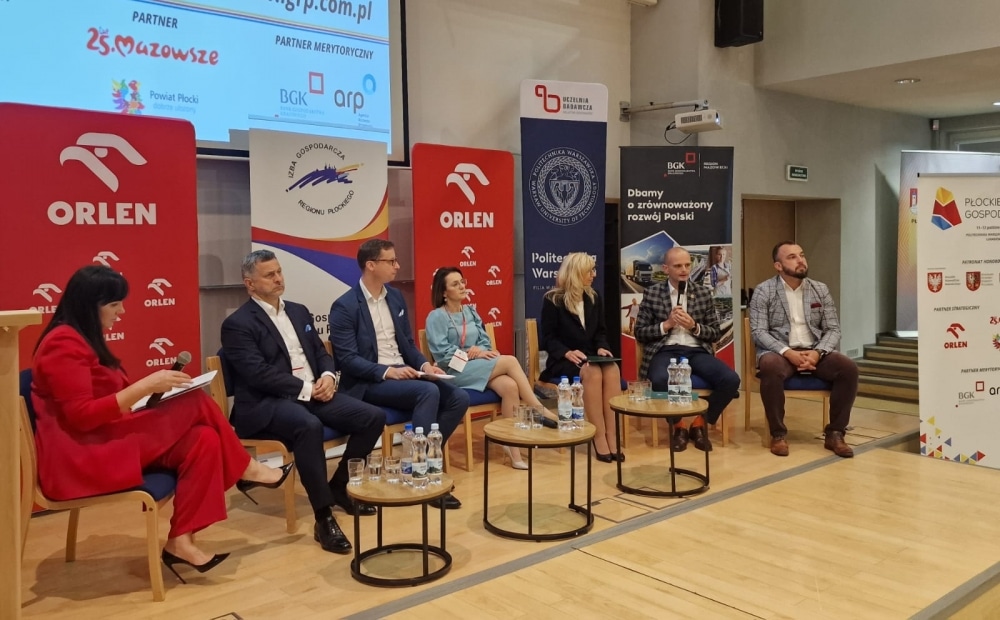 Na zdjęciu przedstawiono panel dyskusyjny podczas III Płockiego Forum Gospodarczego, gdzie siedzą uczestnicy w różnych strojach, a w tle widoczne są logotypy sponsorów.