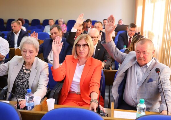 Na zdjęciu widać radnych podnoszących ręce podczas głosowania na sesji.