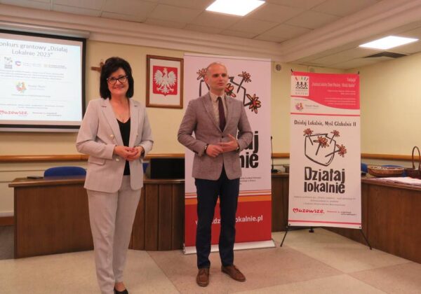 Na zdjęciu widać dwóch prelegentów podczas wydarzenia dotyczącego konkursu grantowego "Działaj Lokalnie 2023", stojących przed banerami promującymi inicjatywę.