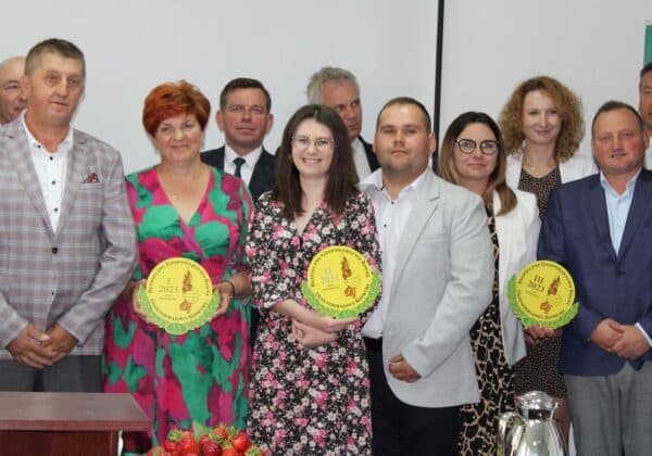 Na zdjęciu ujęto grupę ludzi biorących udział w ceremonii wręczenia nagród, trzymających medale za osiągnięcia w gospodarce.
