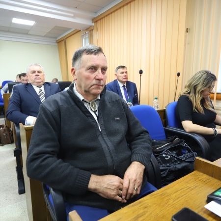 Na zdjęciu widoczni są uczestnicy sesji Rady Powiatu Płock w sali obrad, w tym kilku mężczyzn w garniturach oraz kobieta, wszyscy skupieni na dyskusji.