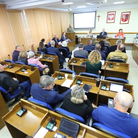 Na zdjęciu przedstawiona jest sala obrad Rady Powiatu Płockiego, wypełniona uczestnikami podczas sesji.