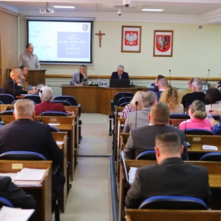 Na zdjęciu przedstawiono sesję Rady Powiatu Płockiego, podczas której radni dyskutują w sali obrad.