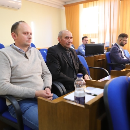 Na zdjęciu przedstawiono czterech mężczyzn siedzących w sali obrad, uczestniczących w sesji rady powiatu w Płocku.