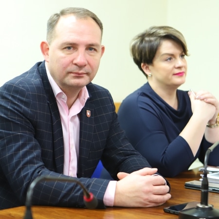 Na zdjęciu widać dwóch uczestników sesji Rady Powiatu w Płocku, siedzących przy stole, z poważnymi wyrazami twarzy.