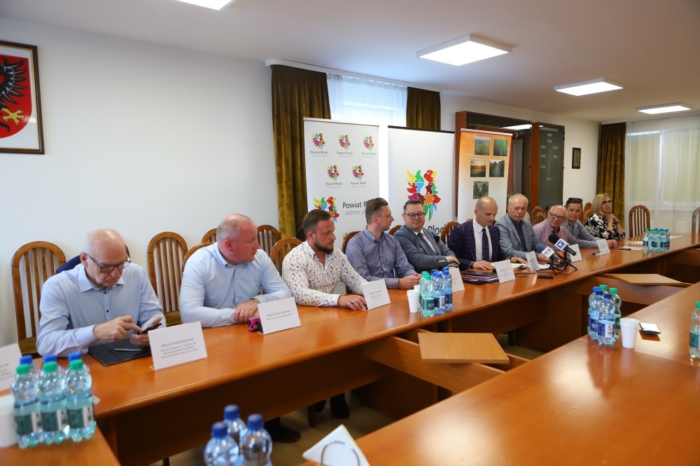 Na zdjęciu przedstawiono spotkanie przedstawicieli samorządowych przy stole, podczas którego omawiane są projekty remontu dróg powiatowych.