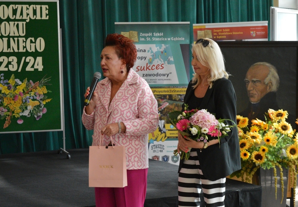 Na zdjęciu przedstawiono dwie kobiety uczestniczące w uroczystości rozpoczęcia roku szkolnego w Zespole Szkół im. Stanisława Staszica w Gabinie, gdzie jedna z nich przemawia do zebranych.