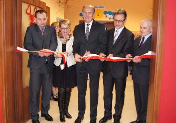 Uczestnicy uroczystego otwarcia Żłobka Samorządowego w Gąbinie w trakcie przecięcia wstęgi.