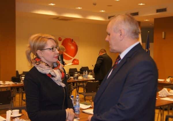 Na zdjęciu przedstawiono rozmowę dwóch osób podczas obrad Konwentu Powiatów Województwa Mazowieckiego w sali konferencyjnej.