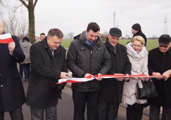 Otwarcie drogi powiatowej Płock–Zągoty-Bonisław z uczestnikami ceremonii trzymającymi wstęgę.