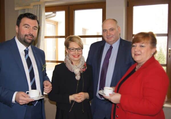 Spotkanie Starosty Płockiego z burmistrzami i wójtami gmin nadwiślańskich w przyjemnej atmosferze, z filiżankami kawy w rękach uczestników.