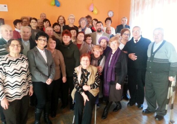 Noworoczne spotkanie z Seniorami w Wyszogrodzie, gdzie uczestnicy pozują grupowo w radosnej atmosferze.