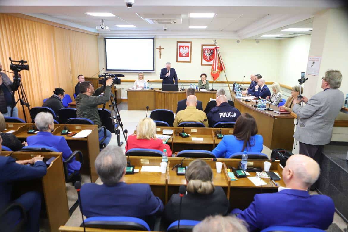 Na zdjęciu widać salę obrad, w której odbywa się spotkanie, z uczestnikami siedzącymi w rzędach oraz prelegentem występującym na podium.