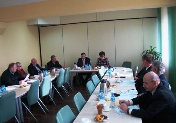 Posiedzenie Powiatowej Rady Zatrudnienia w Płocku, z uczestnikami dyskutującymi przy stole w wyposażonym pomieszczeniu.