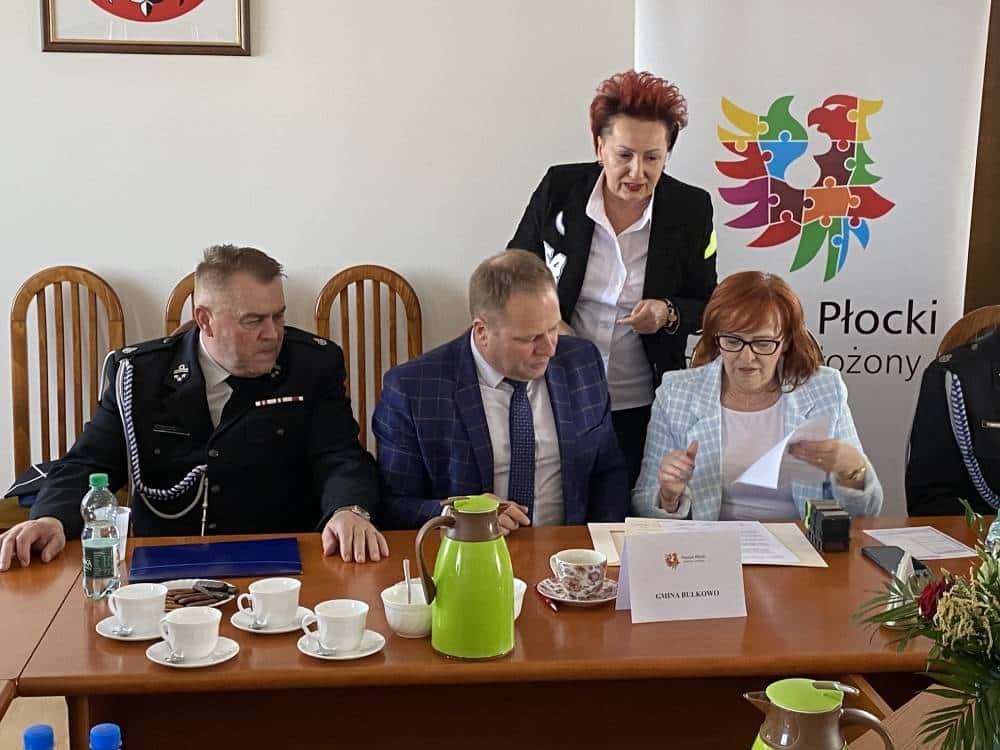 Spotkanie przedstawicieli lokalnych władz i straży pożarnej na konferencji dotyczącej wsparcia dla OSP w powiecie płockim.