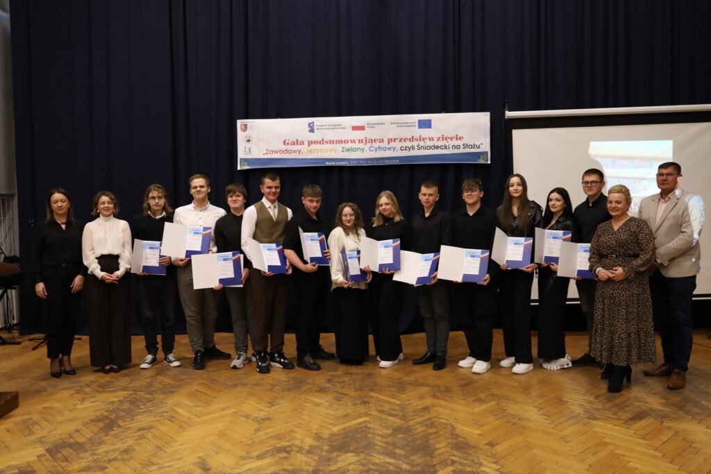 Na zdjęciu widoczna jest grupa uczestników gali podsumowującej projekt FERS, którzy trzymają certyfikaty w towarzystwie organizatorów.