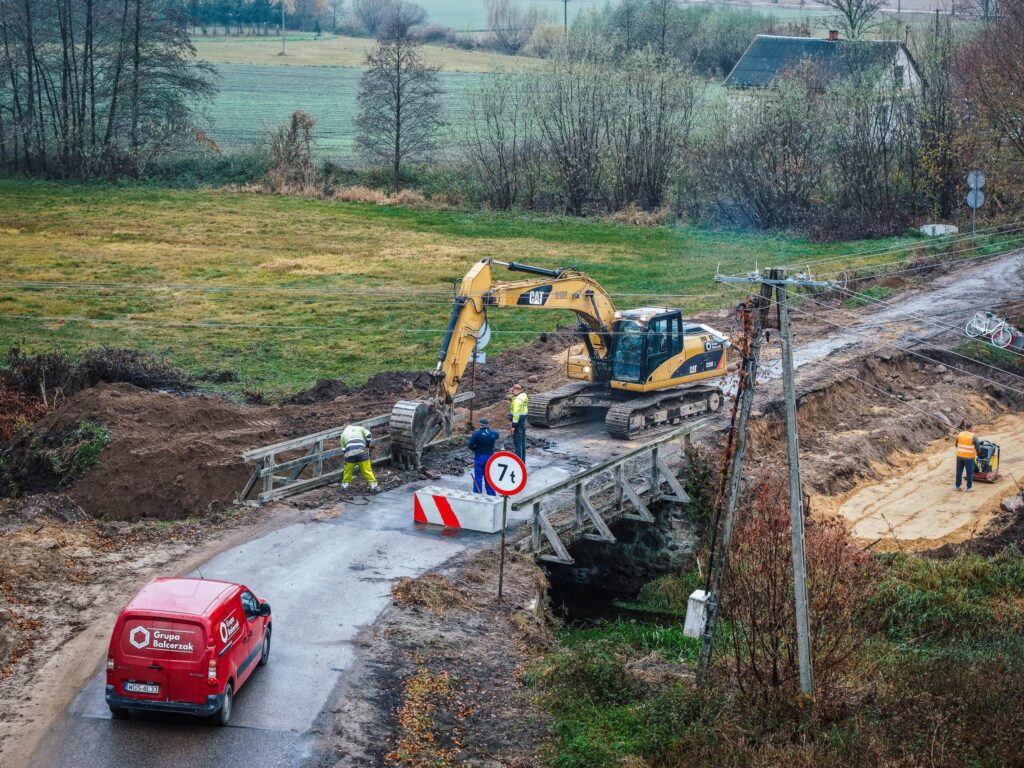 Na zdjęciu przedstawiono prace remontowe drogi, podczas których budowane są dwa nowe mosty, co jest oczekiwaną inwestycją lokalną.