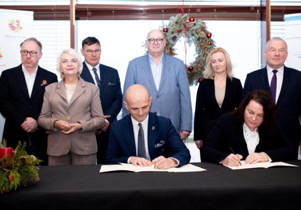 Na zdjęciu prezentuje się grupa osób podczas ceremonii podpisania dokumentów dotyczących przywracania bezpieczeństwa powodziowego w Powiecie Płockim.