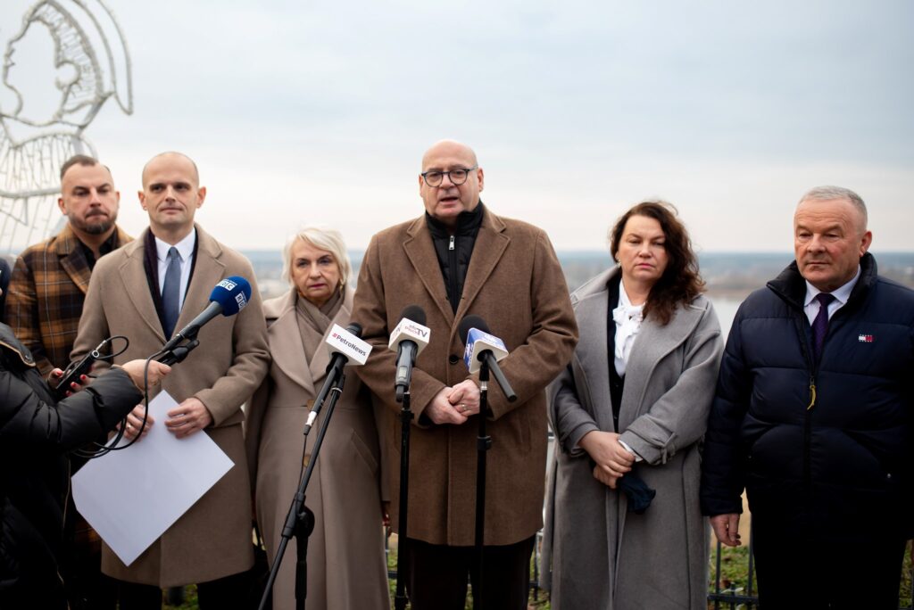 Na zdjęciu przedstawiono kilka osób podczas konferencji prasowej, na której starosta Płocki ogłasza działania mające na celu poprawę bezpieczeństwa powodziowego w regionie.