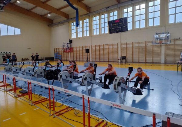 Na zdjęciu widać uczestniczki finału powiatowego zawodów w ergometrze wioślarskim, które rywalizują na urządzeniach w hali sportowej.