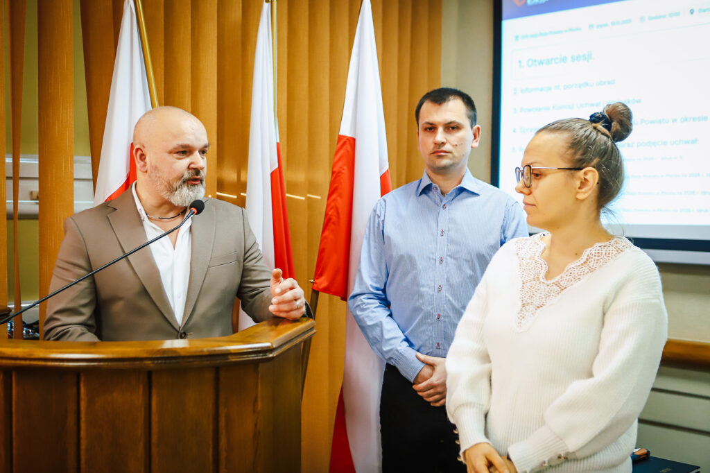 Radni Powiatu Płockiego podczas sesji uchwalają rekordowy budżet, z podium na pierwszym planie.