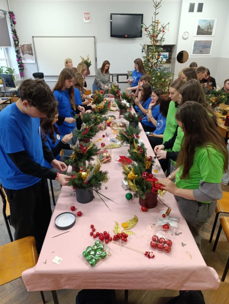 Uczestnicy VIII Powiatowego Spotkania Integracyjnego Szkolnych Klubów Wolontariusza tworzą ozdoby świąteczne na wspólnym warsztacie.