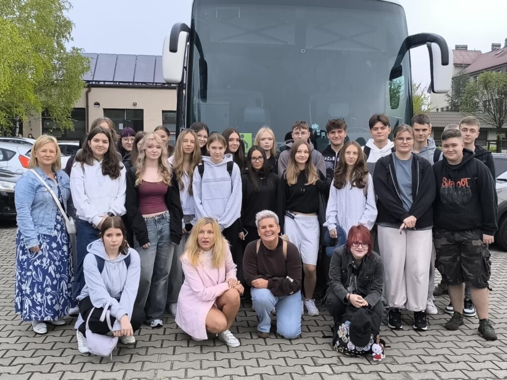 Uczestnicy projektu „Dobre praktyki zagraniczne jako klucz do sukcesu” pozują do zdjęcia przed autokarem.