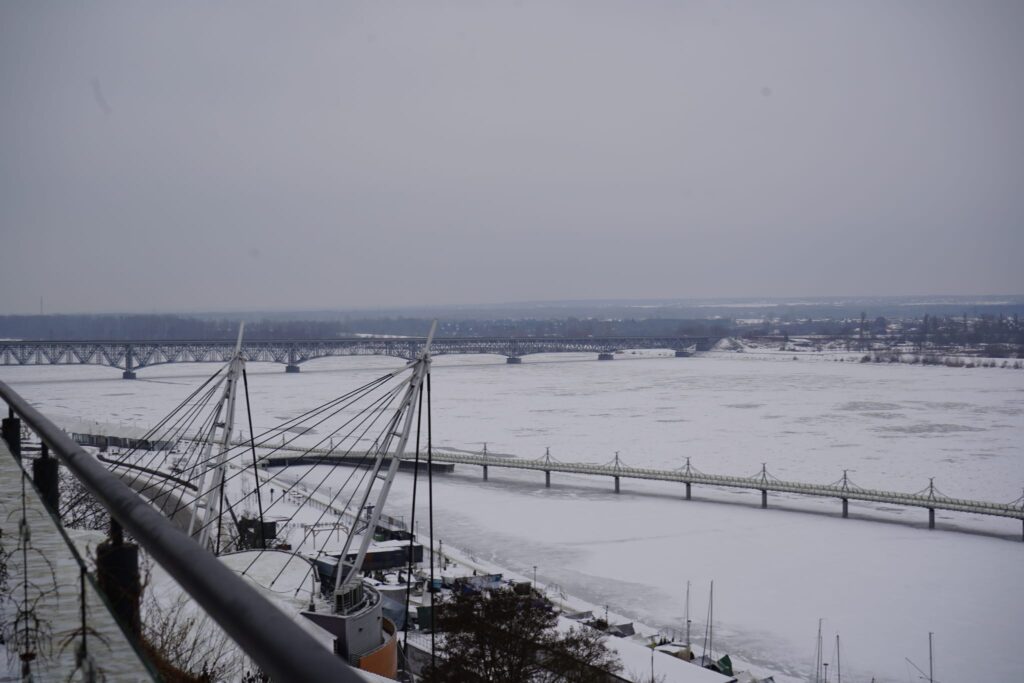 Widok na zamarzniętą rzekę oraz mosty w Powiecie Płockim, podkreślający temat bezpieczeństwa oraz współpracy rządu z samorządem.