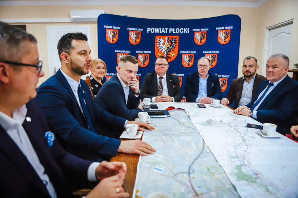 Na zdjęciu przedstawiono spotkanie członków lokalnych władz Powiatu Płockiego, omawiających trasę S10 przy stole z mapą.