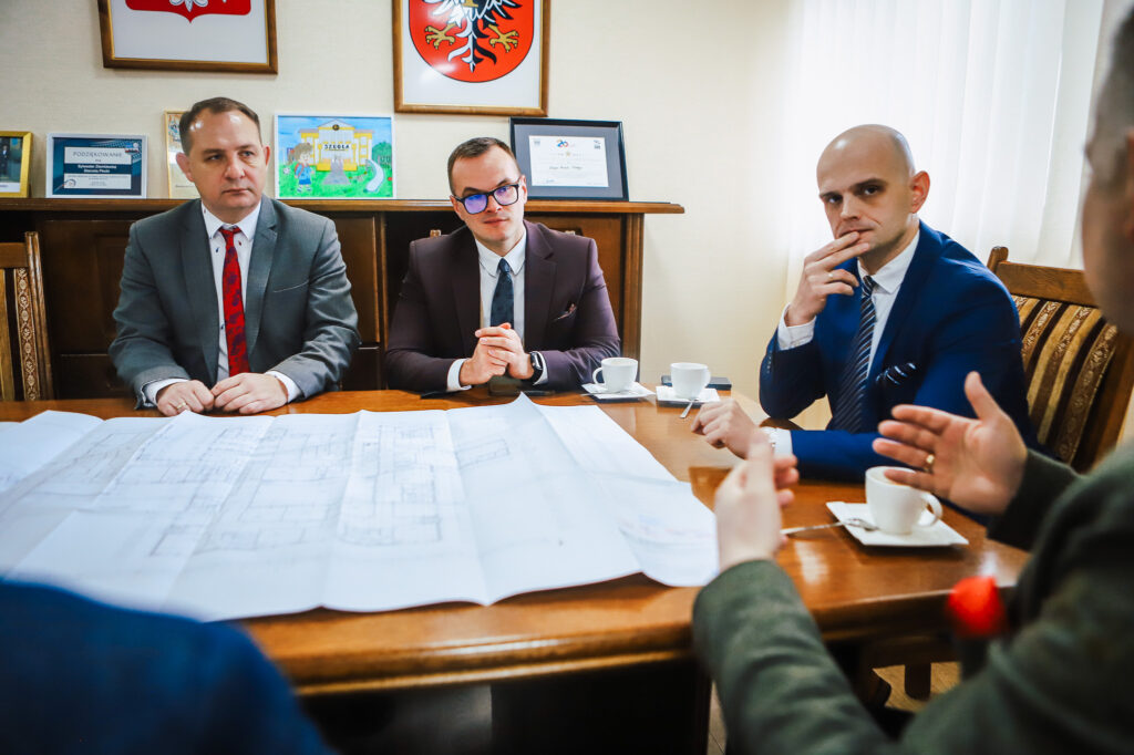 Na zdjęciu przedstawiono spotkanie wiceministra oraz przedstawicieli samorządu w Powiecie Płockim, gdzie omawiane są plany dotyczące współpracy i poprawy bezpieczeństwa.