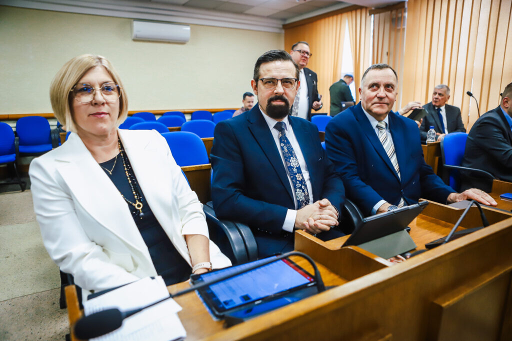 Na zdjęciu widoczni są trzej członkowie Rady Powiatu w Płocku podczas XVIII sesji, siedzący w sali obrad.
