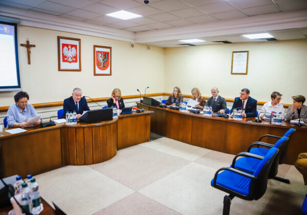 Na zdjęciu przedstawiono XVIII Sesję Rady Powiatu w Płocku, podczas której członkowie rady omawiają ważne kwestie społeczne.