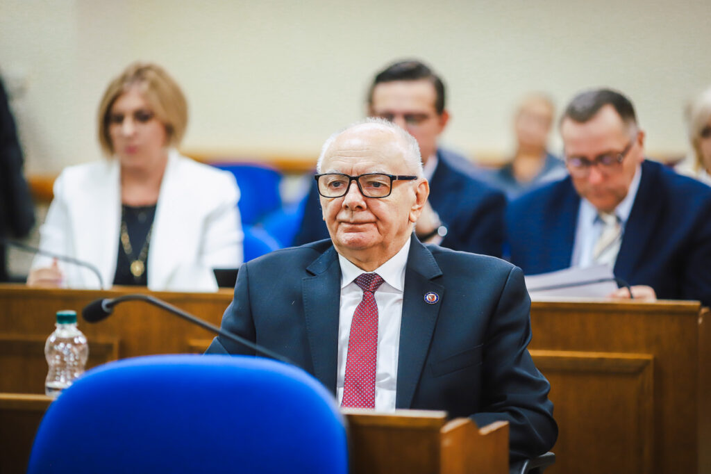 Na zdjęciu przedstawiono członka Rady Powiatu w Płocku podczas XVIII sesji, podczas której omawiane są ważne decyzje i wsparcie społeczne.