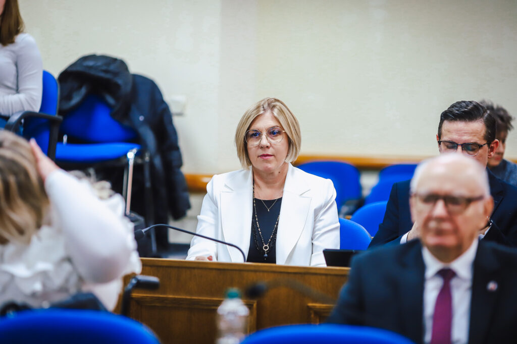 Na zdjęciu widoczna jest uczestniczka XVIII Sesji Rady Powiatu w Płocku, która w skupieniu bierze udział w obradach.