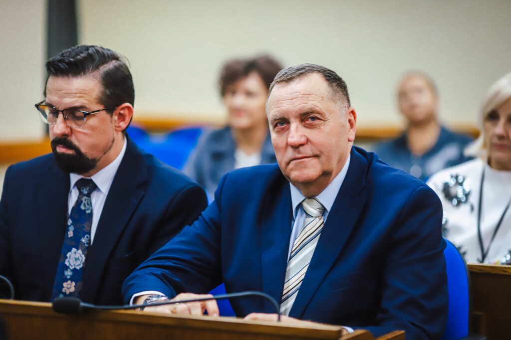 Na zdjęciu widać uczestników XVIII Sesji Rady Powiatu w Płocku, skupionych na omawianiu ważnych kwestii społecznych.