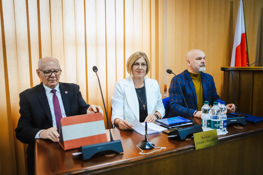 Na zdjęciu przedstawieni są członkowie Rady Powiatu w Płocku podczas XVIII Sesji, podkreślającej jednomyślne decyzje oraz ważne kwestie wsparcia społecznego.